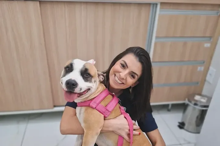 Veterinária da CAV abraçando uma cachorra